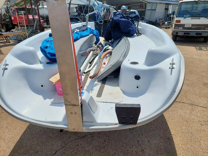 Slide: The Image of 1998 Hunter 170 sailboat with equipment, parked outdoors on a sunny day. - 4