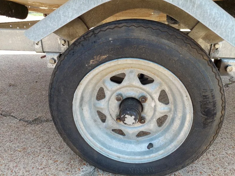 Slide: The Image of Close-up of a 1998 Hunter 170 trailer wheel on a concrete surface. - 6