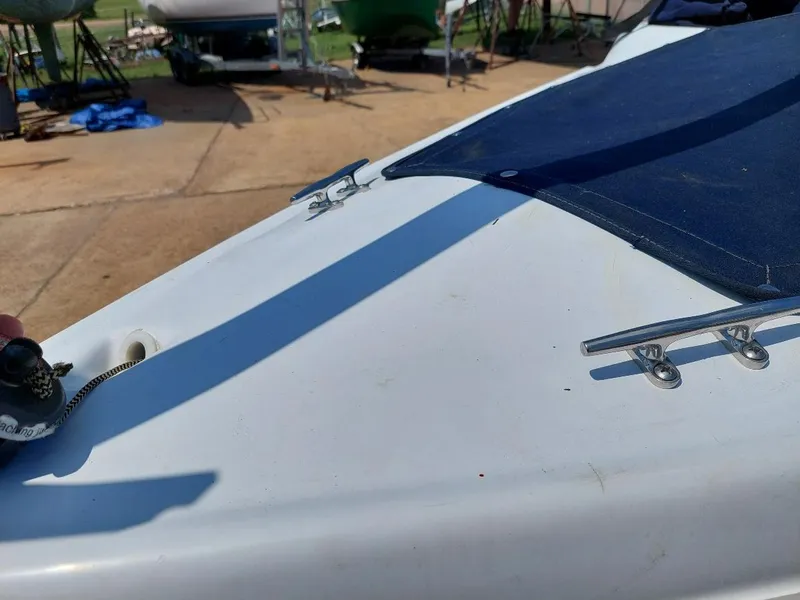 Slide: The Image of Close-up of a 1998 Hunter 170 sailboat deck with cleats and blue cover. - 8