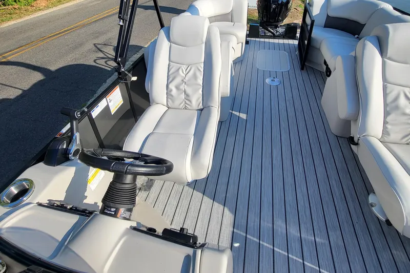 Slide: The Image of 2023 SunCatcher Fusion 322RC boat interior with gray seating and steering wheel. - 10