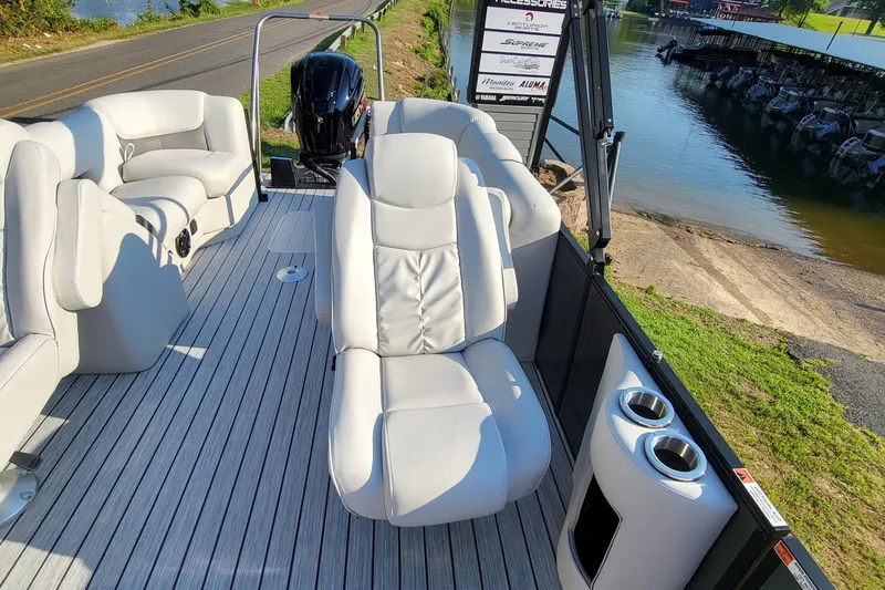 Slide: The Image of 2023 SunCatcher Fusion 322RC pontoon boat with plush seating and cup holders by the water. - 11