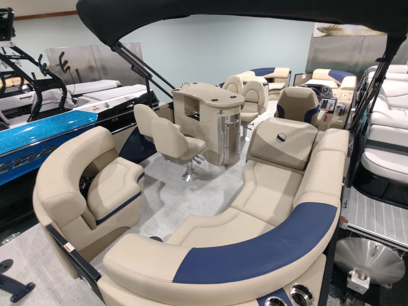 Slide: The Image of 2024 South Bay 523E 2.75 pontoon boat interior with beige and blue seating. - 12