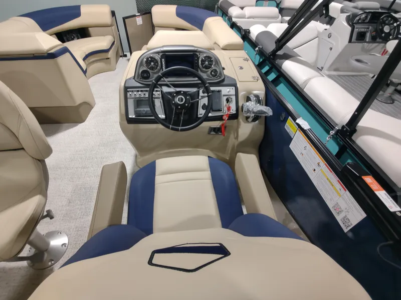 Slide: The Image of 2024 South Bay 523E 2.75 pontoon boat interior with beige and blue seating. - 14