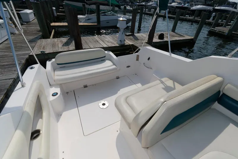 Slide: The Image of 1998 Wellcraft 260 SE boat interior with white seating at a marina. - 4