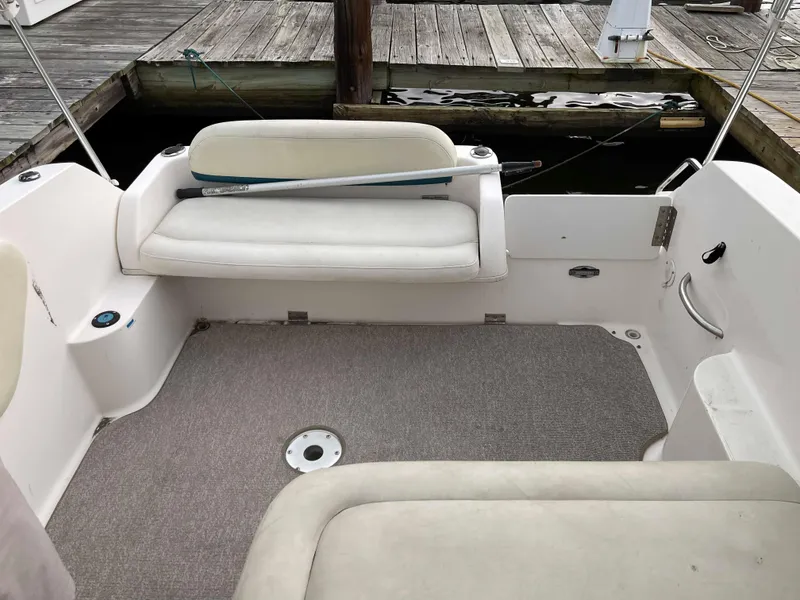 Slide: The Image of 1998 Wellcraft 260 SE boat interior with seating and dock background. - 6