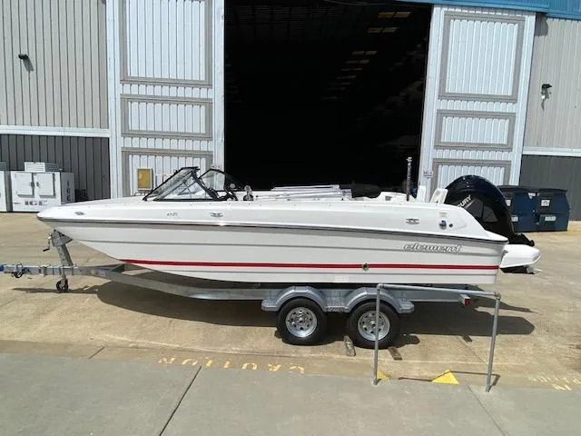 Slide: The Image of 2024 Bayliner Element E21 boat on a trailer outside a warehouse. - 2