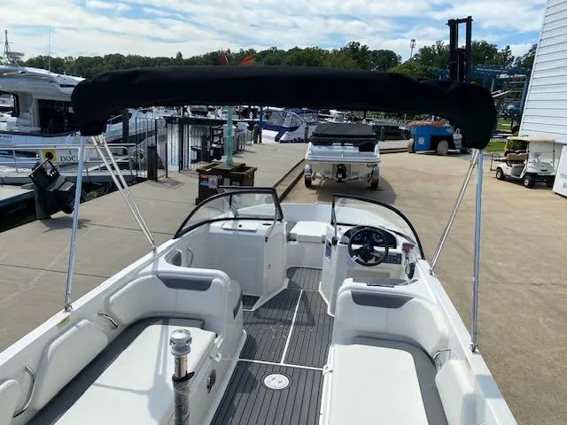Slide: The Image of 2024 Bayliner Element E21 boat with black bimini top at marina. - 24