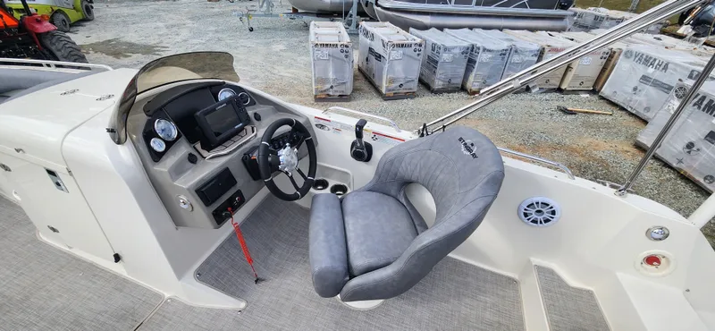 Slide: The Image of 2022 Stingray 212SC boat cockpit with steering wheel, control panel, and captain's chair. - 12