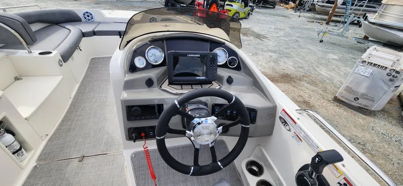 Slide: The Image of 2022 Stingray 212SC boat dashboard with steering wheel, gauges, and navigation system. - 13