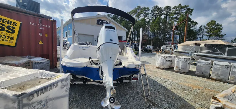Slide: The Image of 2022 Stingray 212SC boat with outboard motor in a marina storage area. - 5