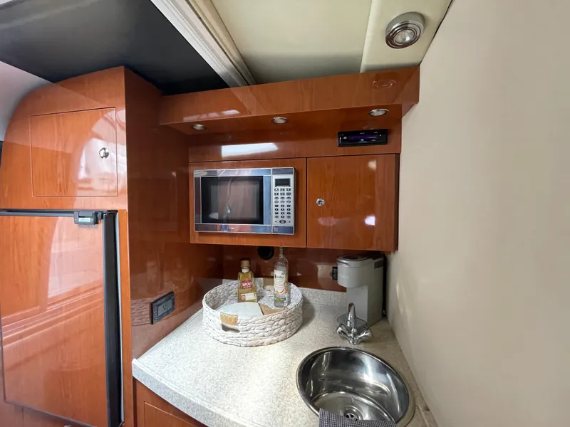 Slide: The Image of 2005 Regal Commodore 3560 IB yacht kitchen with microwave, sink, and fridge. - 10