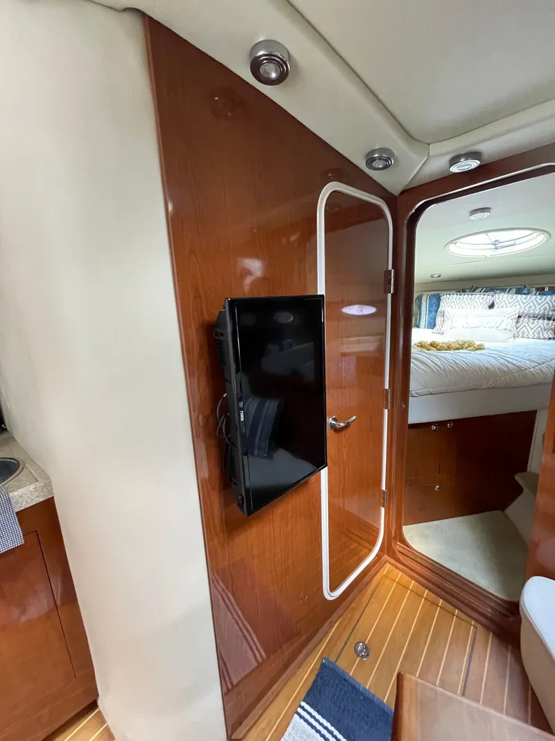 Slide: The Image of Interior of 2005 Regal Commodore 3560 IB yacht with wood paneling and mounted TV. - 11
