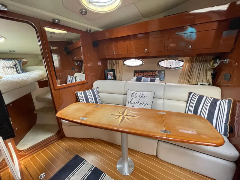 Slide: The Image of 2005 Regal Commodore 3560 IB yacht interior with wood finishes and cozy seating area. - 14