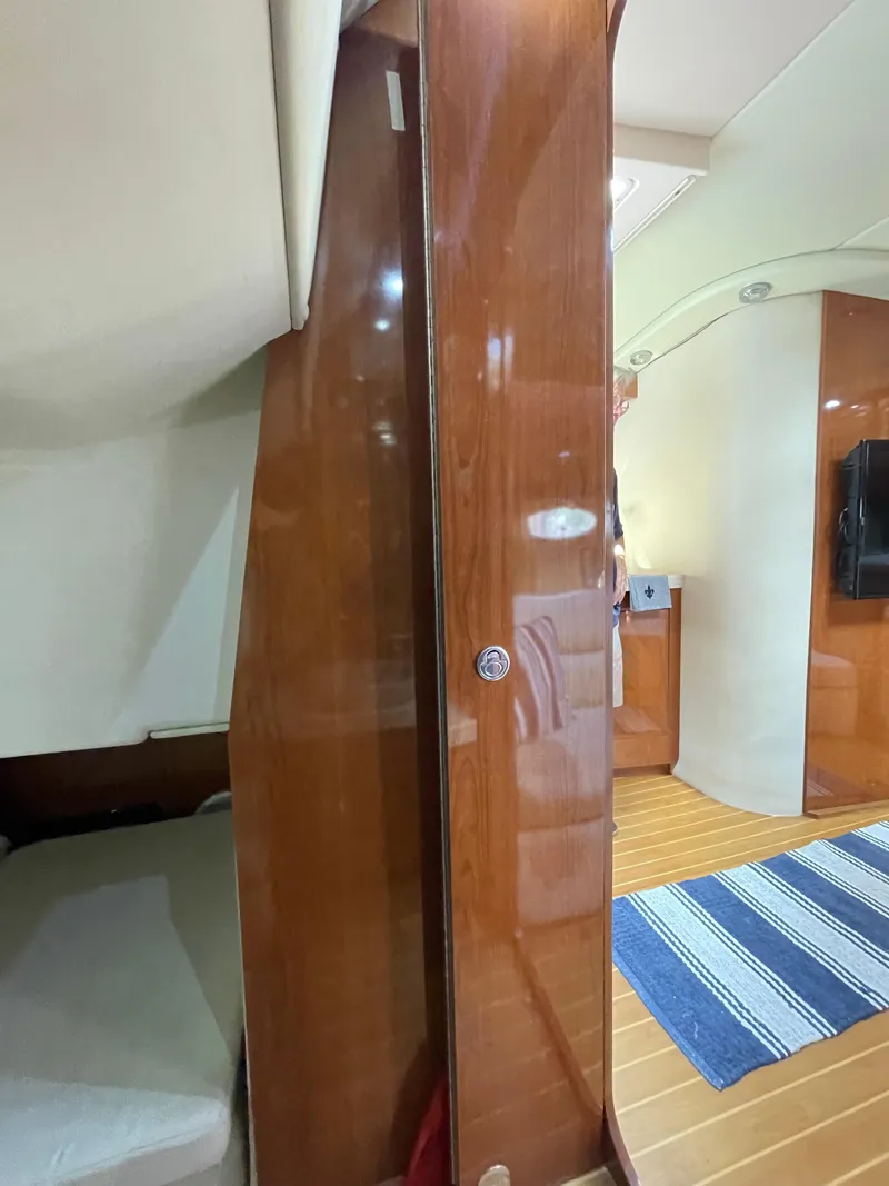 Slide: The Image of Interior of 2005 Regal Commodore 3560 IB yacht with wooden finishes and cozy sleeping area. - 17