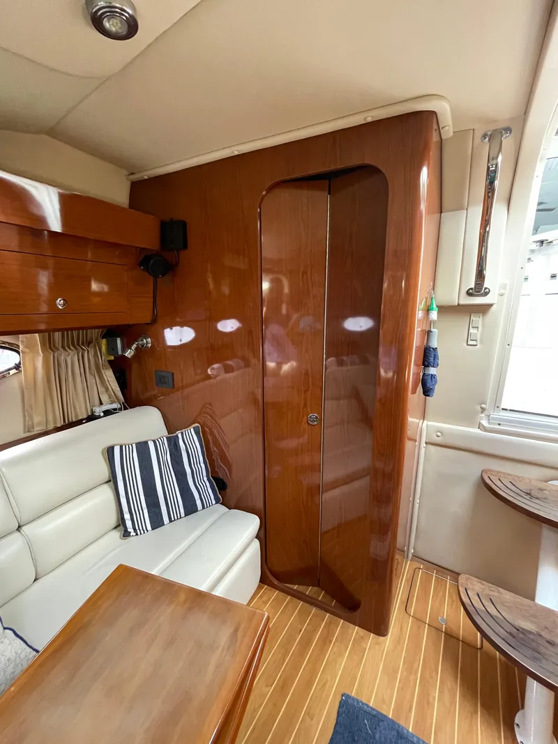 Slide: The Image of Interior of 2005 Regal Commodore 3560 IB yacht with wooden finishes and white seating. - 28
