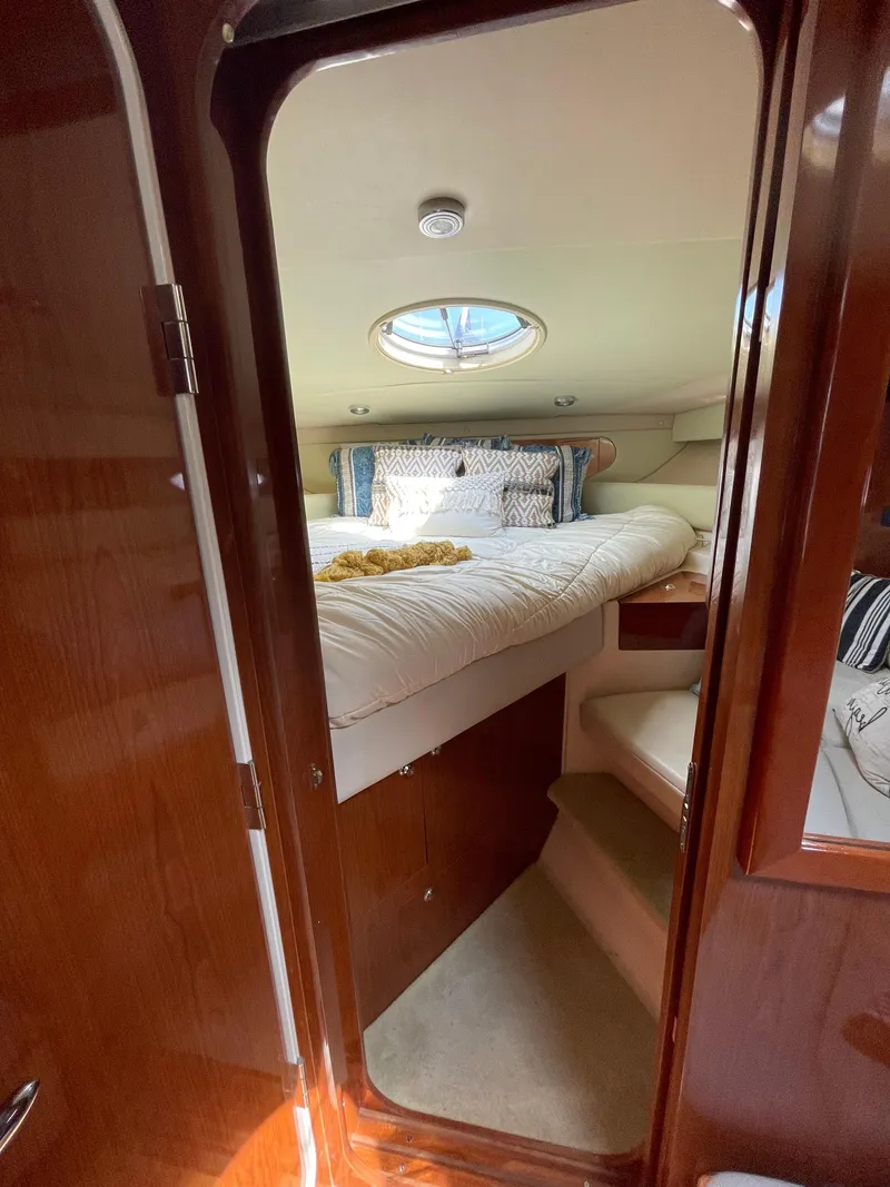 Slide: The Image of Cozy bedroom interior of 2005 Regal Commodore 3560 IB yacht with porthole and plush bedding. - 35