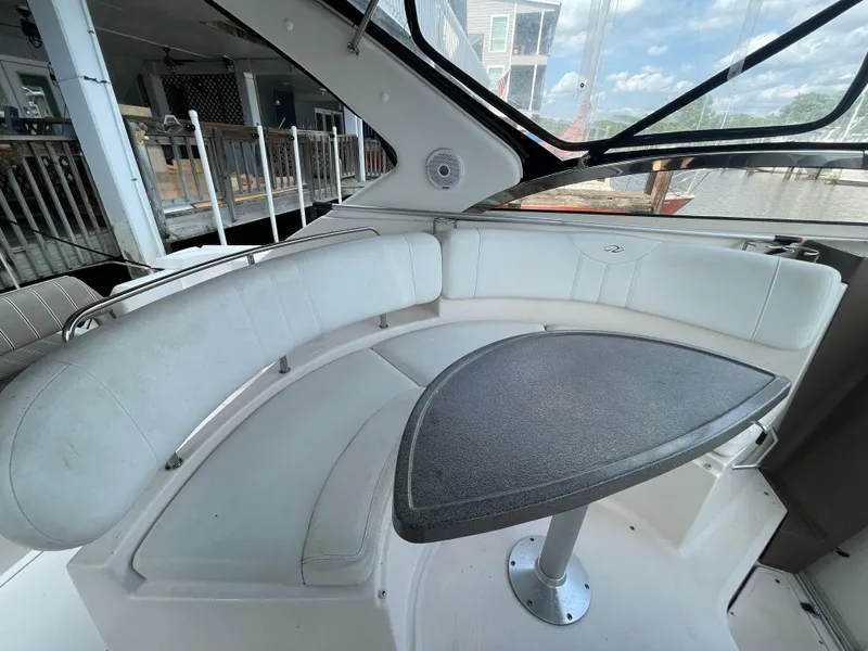 Slide: The Image of 2005 Regal Commodore 3560 IB boat interior with curved seating and table. - 4