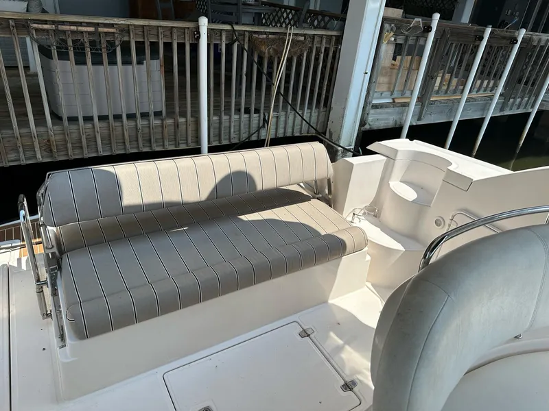 Slide: The Image of 2005 Regal Commodore 3560 IB boat seating area with striped cushions. - 8
