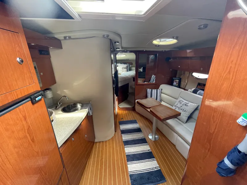 Slide: The Image of 2005 Regal Commodore 3560 IB yacht interior with kitchenette, seating area, and bed. - 9