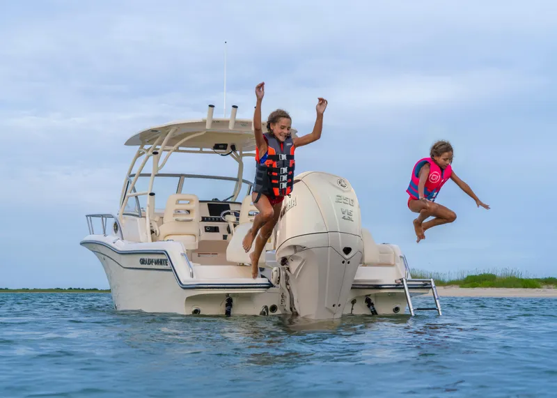 Slide: The Image of Children jumping off 2025 Grady-White Adventure 218 boat into the water. - 16