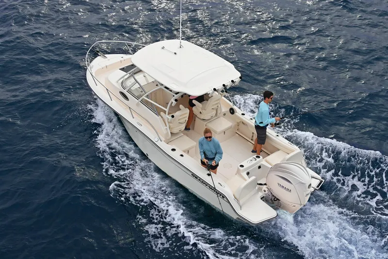 Slide: The Image of 2025 Grady-White Adventure 218 boat cruising on open water with two people onboard. - 17