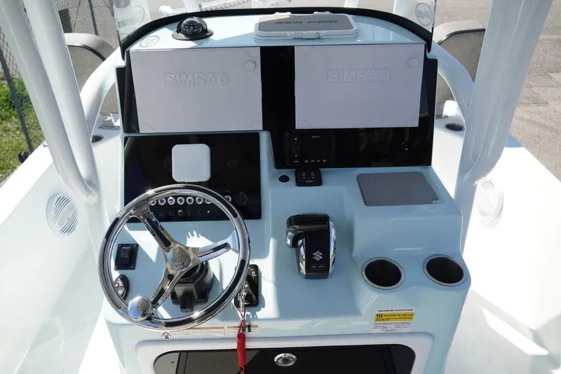 Slide: The Image of 2024 Sea Pro 248 DLX BAY boat console with steering wheel and Simrad displays. - 6