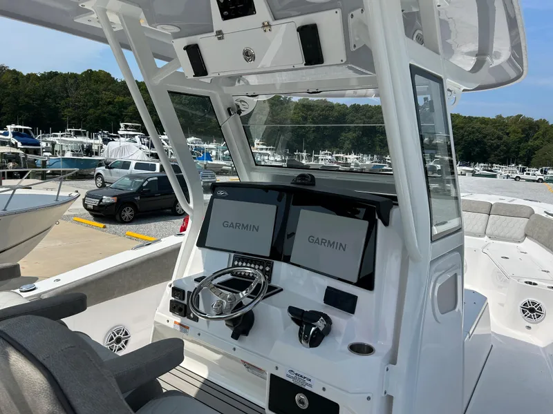 Slide: The Image of 2024 Sea Fox 328 Commander boat dashboard with Garmin displays at a marina. - 8