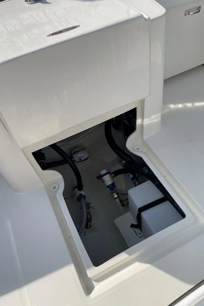 Slide: The Image of 2024 Pathfinder 2400 Open boat storage compartment with visible wiring and components. - 15