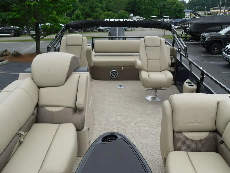Slide: The Image of 2024 Regency 250 DL3 pontoon boat interior with beige seating and spacious layout. - 14