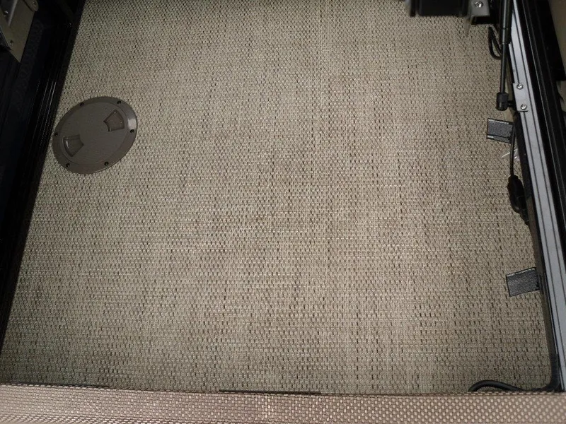 Slide: The Image of 2024 Regency 250 DL3 interior flooring with textured carpet and circular access panel. - 19