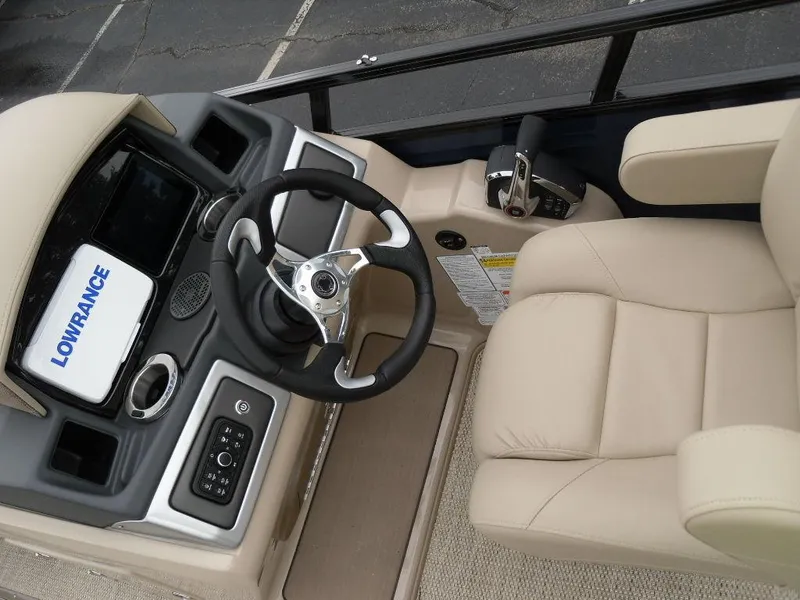 Slide: The Image of 2024 Regency 250 DL3 boat helm with steering wheel and beige captain's chair. - 26