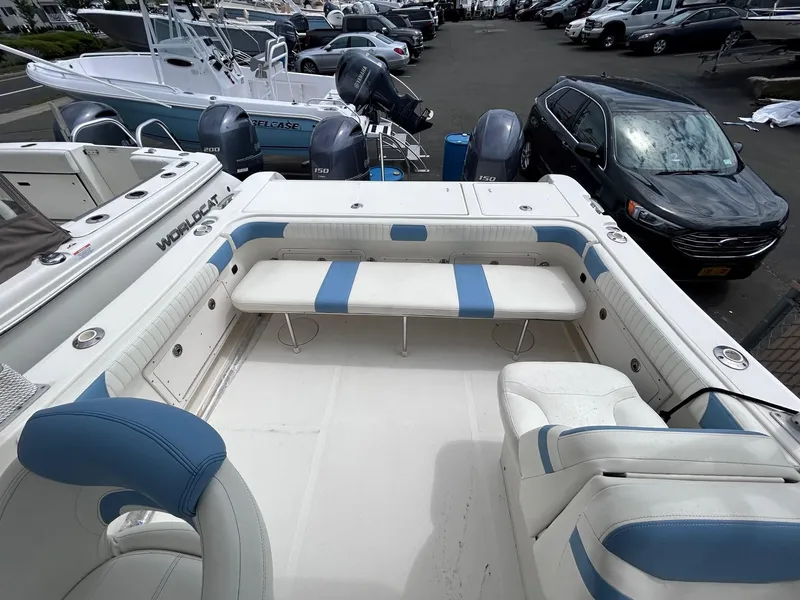 Slide: The Image of 2007 World Cat 250 DC boat interior with blue and white seating, parked in a marina. - 2