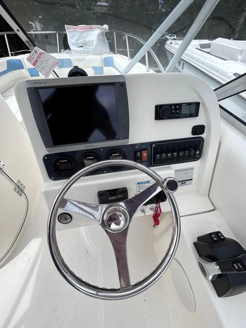 Slide: The Image of 2007 World Cat 250 DC boat dashboard with steering wheel and control panel. - 5