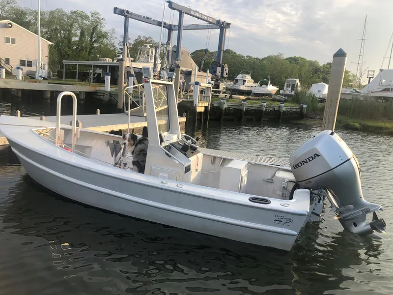 Slide: The Image of Custom 19 Center Console boat, 2021 model, docked with Honda outboard motor. - 1