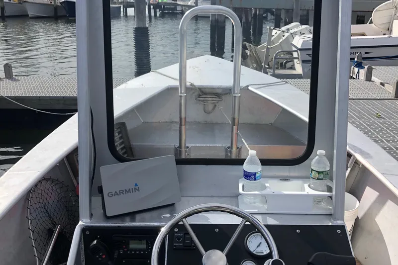 Slide: The Image of Custom 19 Center Console boat interior with Garmin device, docked at marina, 2021 model. - 4