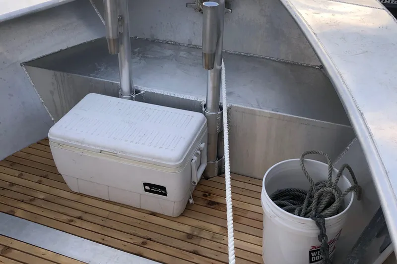 Slide: The Image of 2021 Custom 19 Center Console boat interior with cooler, bucket, and wooden deck. - 6