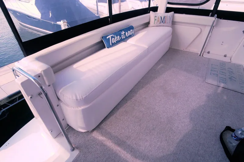 Slide: The Image of Interior of 2000 Silverton 392 Motor Yacht with white seating and decorative pillows. - 25