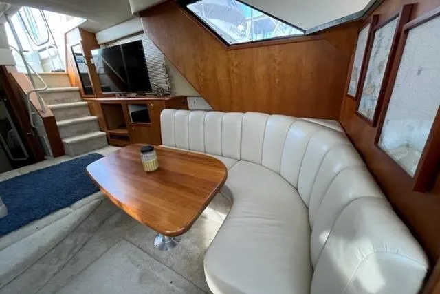 Slide: The Image of 2000 Silverton 392 Motor Yacht interior with white leather seating and wooden table. - 37