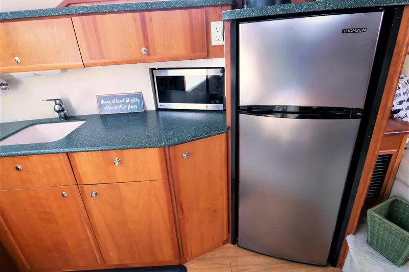 Slide: The Image of Interior of 2000 Silverton 392 Motor Yacht with kitchen appliances and wooden cabinetry. - 41