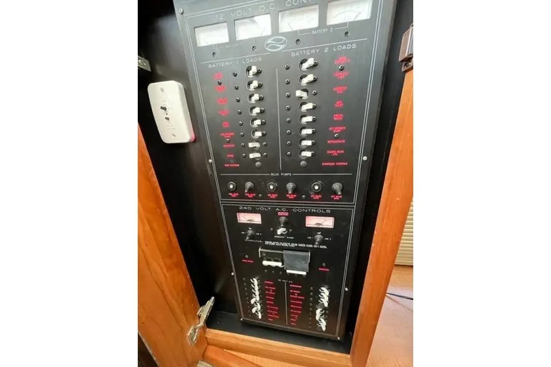Slide: The Image of Control panel of a 2000 Silverton 392 Motor Yacht, featuring electrical switches and meters. - 47