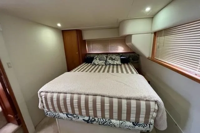 Slide: The Image of Bedroom interior of 2000 Silverton 392 Motor Yacht with cozy bed and striped bedding. - 53