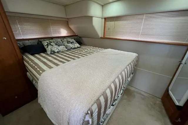 Slide: The Image of Cozy bedroom in 2000 Silverton 392 Motor Yacht with striped bedding and decorative pillows. - 54