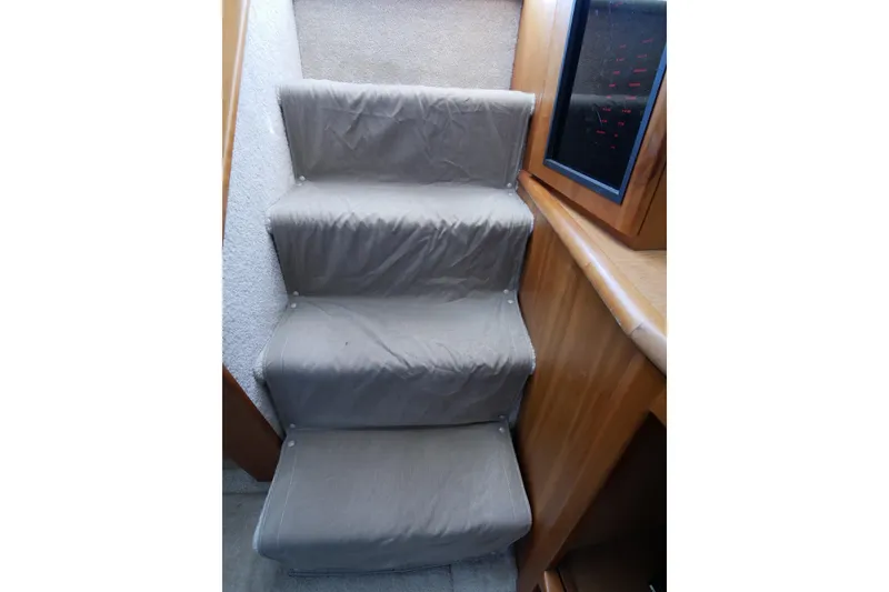 Slide: The Image of Interior stairs of 2000 Silverton 392 Motor Yacht with carpeted steps and wooden paneling. - 49