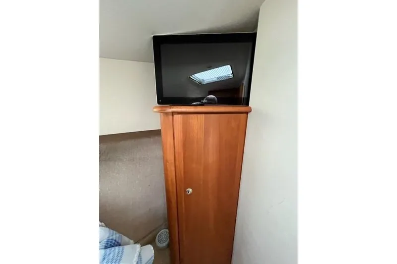 Slide: The Image of Interior of 2000 Silverton 392 Motor Yacht with TV on wooden cabinet. - 52