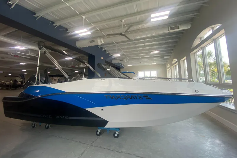 Slide: The Image of 2024 Starcraft SVX 190 boat in showroom, blue and white exterior. - 2