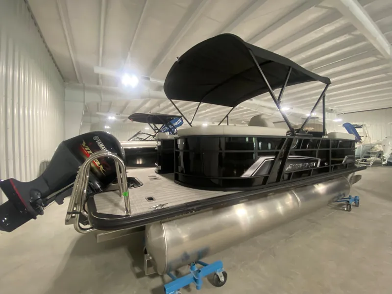 Slide: The Image of 2024 Starcraft EXS 1 pontoon boat in indoor showroom. - 2