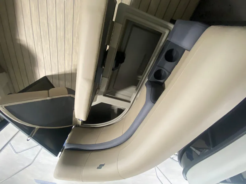 Slide: The Image of 2024 Starcraft EXS 1 boat interior with beige seating and cup holders. - 17