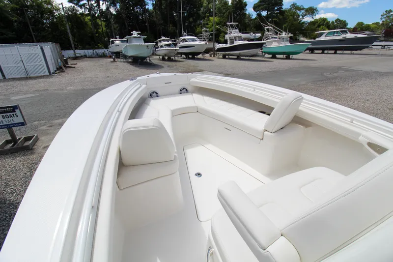 Slide: The Image of 2024 Regulator 23 boat interior with white seating, displayed at a boatyard. - 12