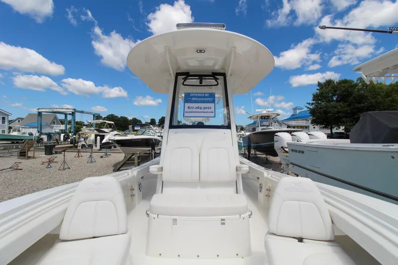 Slide: The Image of 2024 Regulator 23 boat on display at a marina under a clear blue sky. - 14