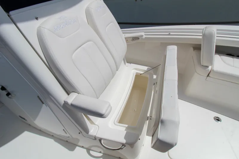Slide: The Image of 2024 Regulator 23 boat with white cushioned seats and storage compartment. - 17